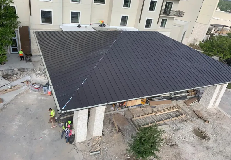 Metal roofing installation team working on a commercial building in Scott